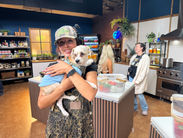 Smiling woman holding small dog on set
