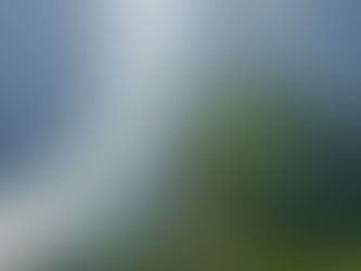 River winding through green mountains; a boat travels along the water. Sunlight reflects on the surface, creating a serene atmosphere.