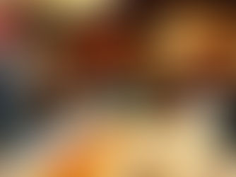 Plate of golden-brown dumplings held in front of a bustling street food stall with glowing yellow signage, creating a warm and inviting mood.