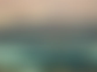 Cityscape with tall buildings under a hazy pink sky. Green parks, trees, and lakes in the foreground create a serene mood.