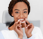 Femme adulte utilisant une gouttière invisible, illustrant l’orthodontie discrète pour adultes