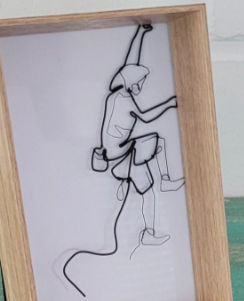 Miniaturbild: Bergsteiger aus Draht im Rahmen