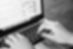 Hands typing on laptop