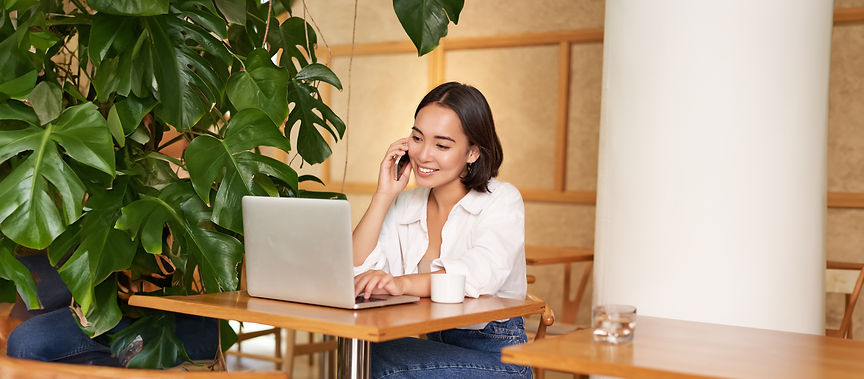 stylish-young-woman-answer-phone-call-sitting-cafe-with-laptop-working-taling-smartphone.j