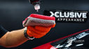 Technician applying ceramic coating with a microfiber cloth to a red vehicle at Xclusive Appearance.