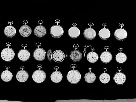 A collection of vintage pocket watches on a black background, some open to show intricate gears. The scene is elegant and nostalgic. article by sheridan guerrette