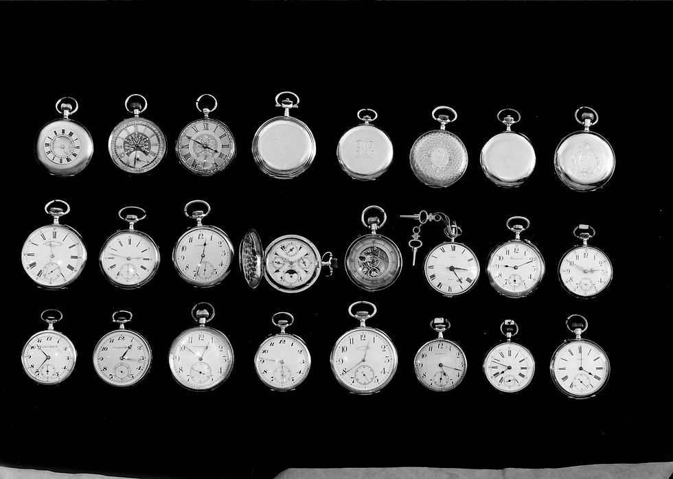A collection of vintage pocket watches on a black background, some open to show intricate gears. The scene is elegant and nostalgic.