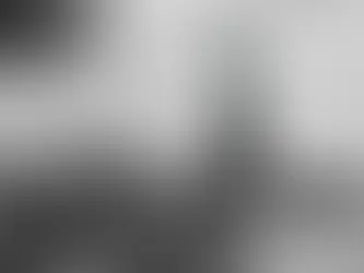 Crowd on a boat gazes at the Statue of Liberty on a cloudy day. The mood is anticipative, with the iconic landmark in the distance.