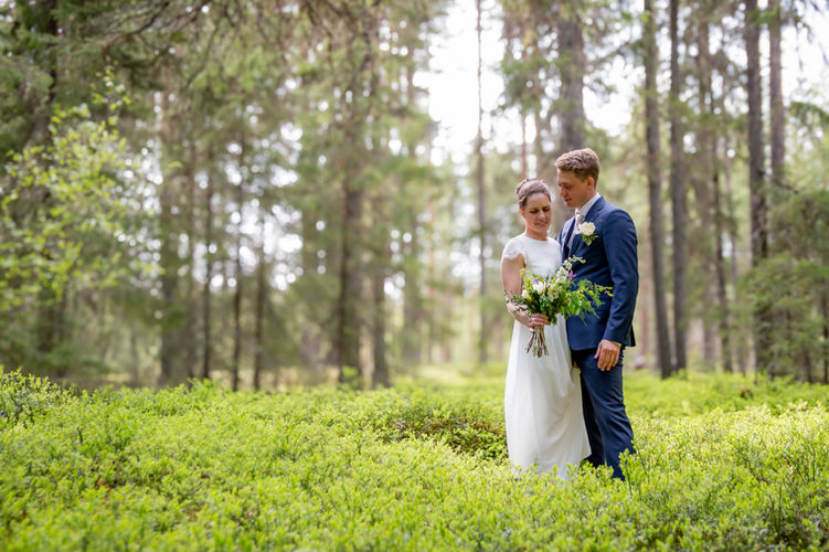 Bröllopspar i skog.