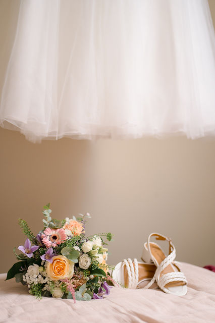 Bouquet de fleurs et chaussures de mariée, robe blanche, jour du mariage.