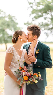 Un couple s'embrassant, une mariée tenant un bouquet. Mariage, nature, amour, bonheur.