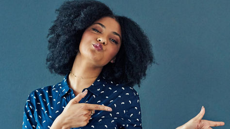 A woman points and smiles.