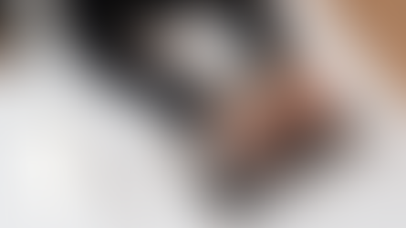 A person typing on a laptop with a mobile phone with the Perplexity app open on it sitting on the table next to them.