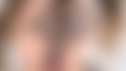 Close-up of a young child holding a magnifying glass up to their eye, enlarging it dramatically while they look curiously at the camera.