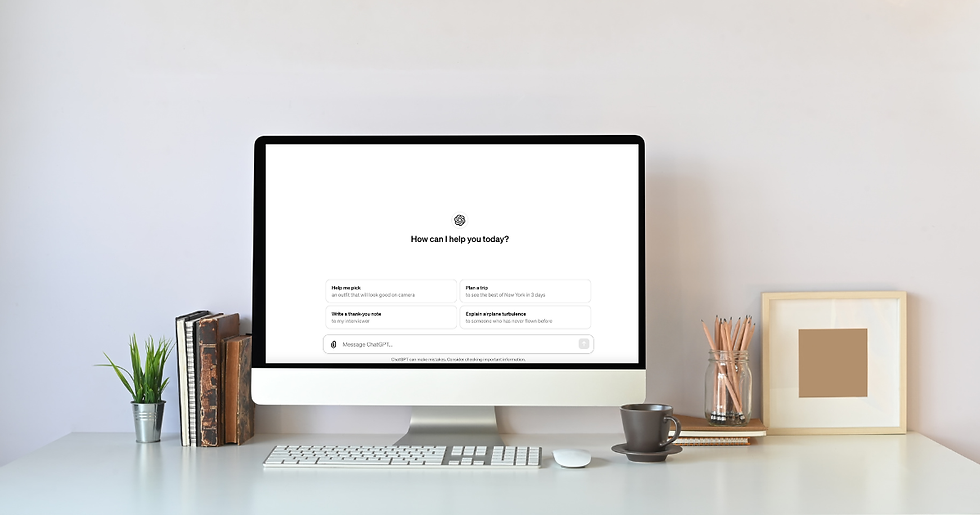 Desktop computer on a minimalist desk displaying the ChatGPT home screen, with books, a small plant, pencils, framed art, and a coffee cup.