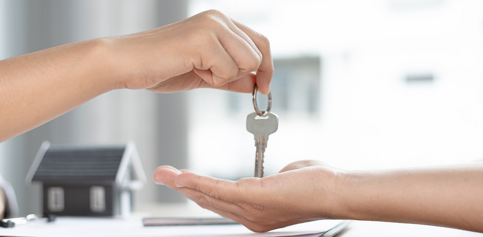 A person handing a house key to another person.