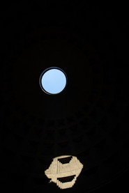 The Pantheon oculus casting a circle of sunlight across the dark coffered dome.
