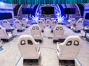 Space-themed experiential activation setup with white cockpit chairs and sci-fi backdrop.