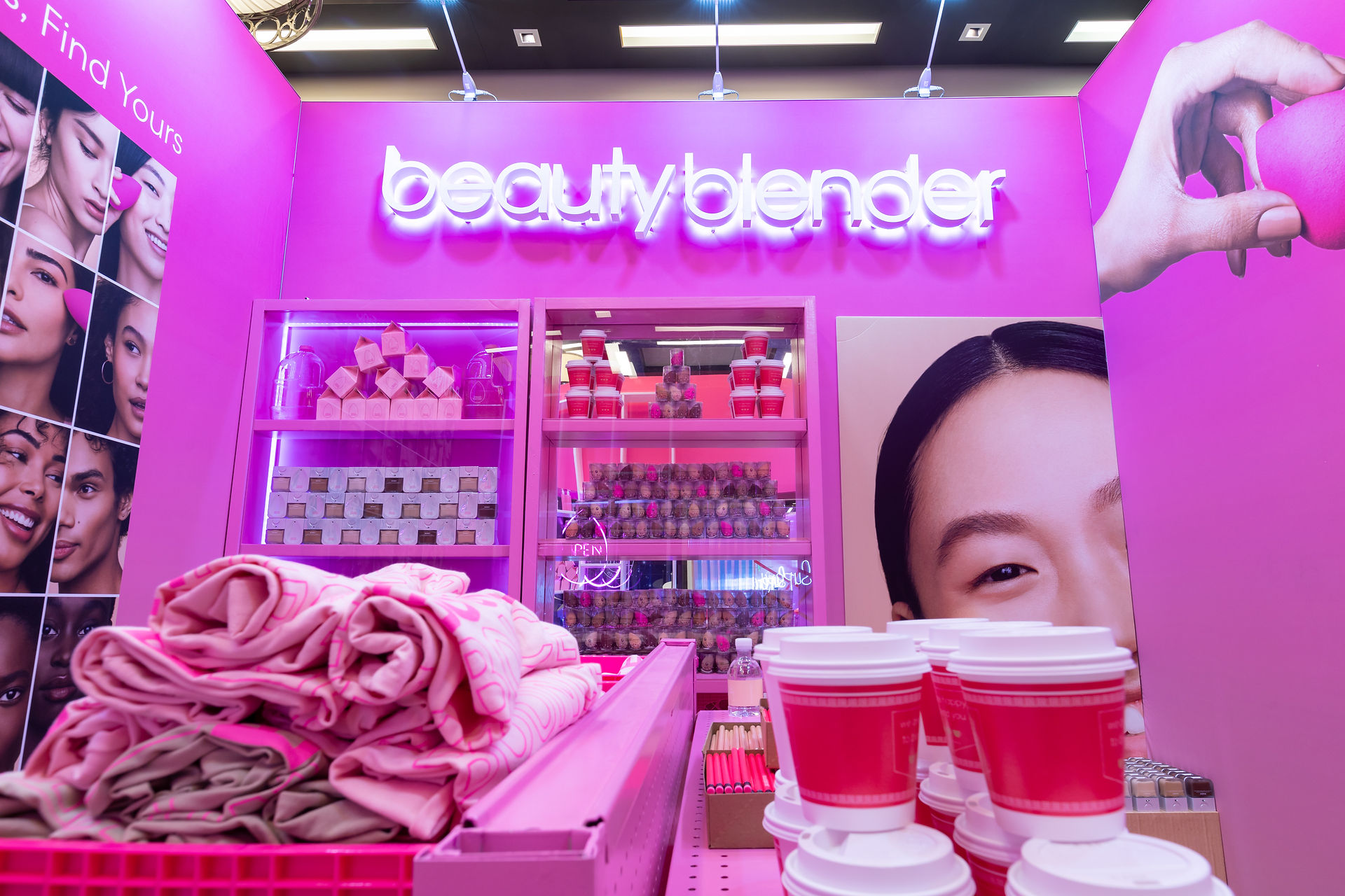 Full frontal view of Beautyblender tradeshow booth with bright branding and merchandise.