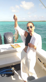 young lady showing her catch on a fishing charter in exuma