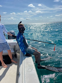 man just about to dive off boat to snorkel in Exuma water