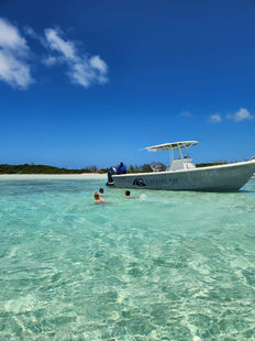 family and friends swimming by the crystal bay boat in exuma bahamas on a beuatiful sunny day