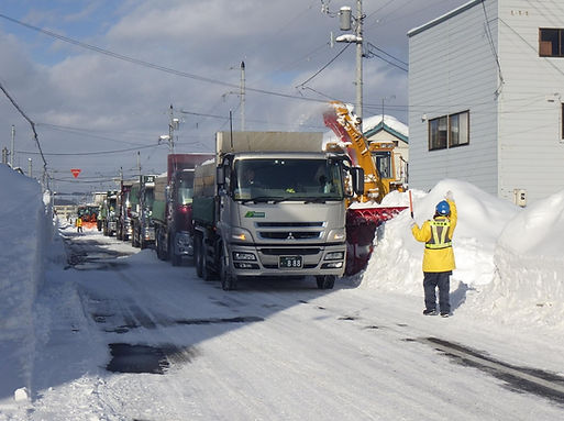 除雪された道を通行する車