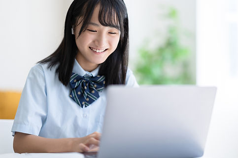パソコンを操作する笑顔の女子学生