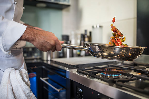 chef-holding-frying-pan-cooking-food-over-stove-2022-03-04-01-45-46-utc.jpg