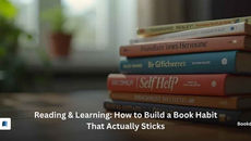 Colorful stack of books on a table in a blurred room, overlaid with Reading & Learning: How to Build a Book Habit That Actually Sticks