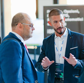 Tre uomini d'affari conversano a un evento aziendale.