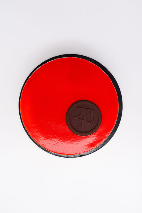 Torta rotonda rossa con decoro al cioccolato