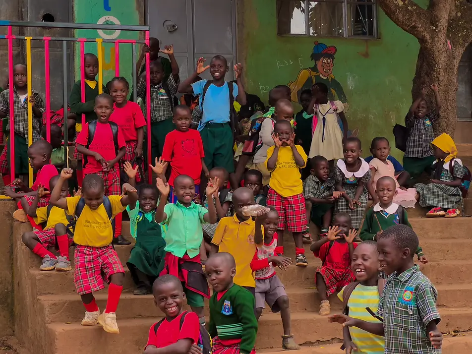 Smiling children on school steps in Uganda