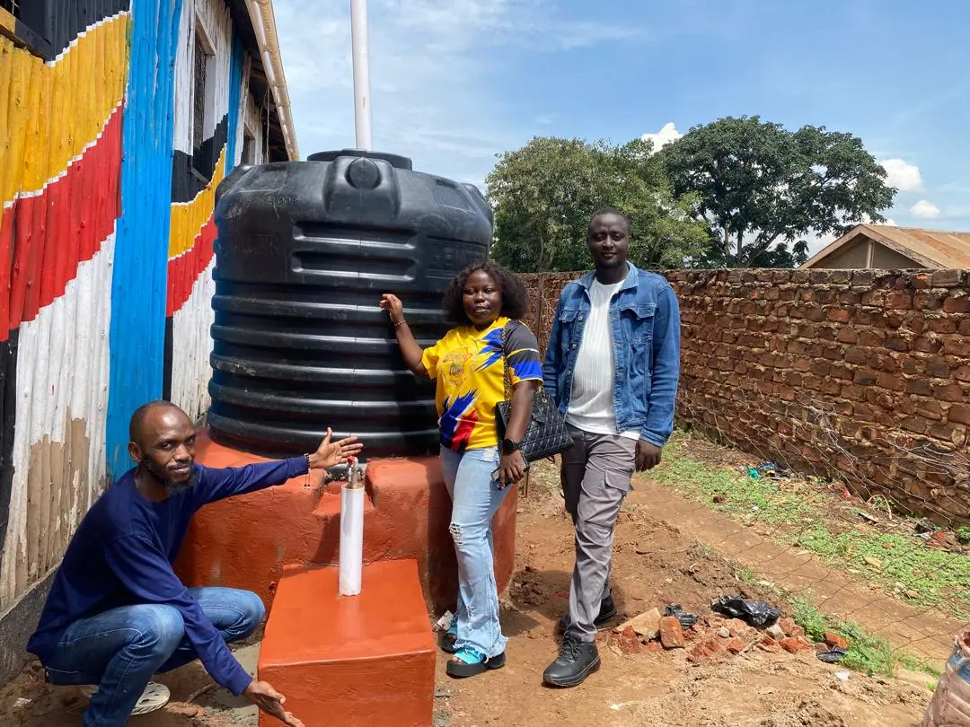 Team Speakers for Africa standing by the water tank