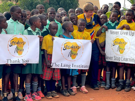 Never Stop Learning. Kids hold a sign at school