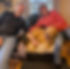 Smiling couple sitting with their golden retriever on a leather chair.
