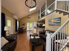 Modern open-plan living room with vaulted ceiling and loft.