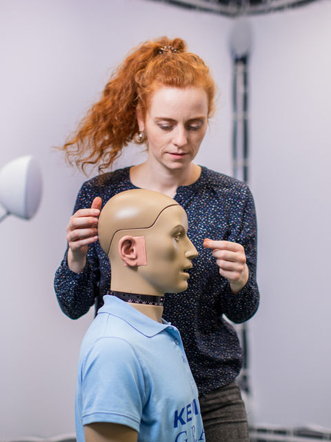 Teresa Wenhart im Schallisolierten Raum mit Messequipment an einem Kunstkopf