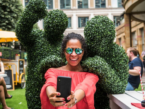 Human Hedge Entertainers take a selfie at a festival event in Canary Wharf London.