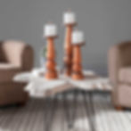 Three candlesticks with lit candles sit on a white irregular coffee table.