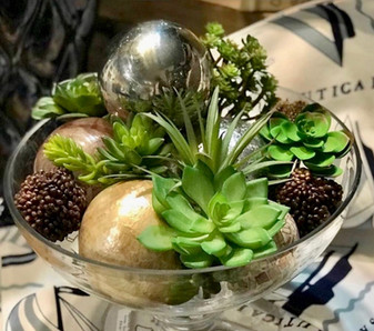 Glass bowl with faux succulents, faux pine cones and silver and gold spheres
