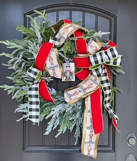 Festive Christmas wreath on black door with red and black ribbons