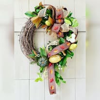 Autumn wreath with ribbons and pumpkins, perfect for fall season decor.