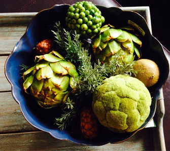 Blue bowl with green faux artichokes, greenery and acorn pods