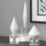 White geometric decor on a table with a watercolor art piece in background