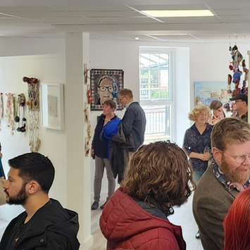 People at exhibition with self portrait in the background