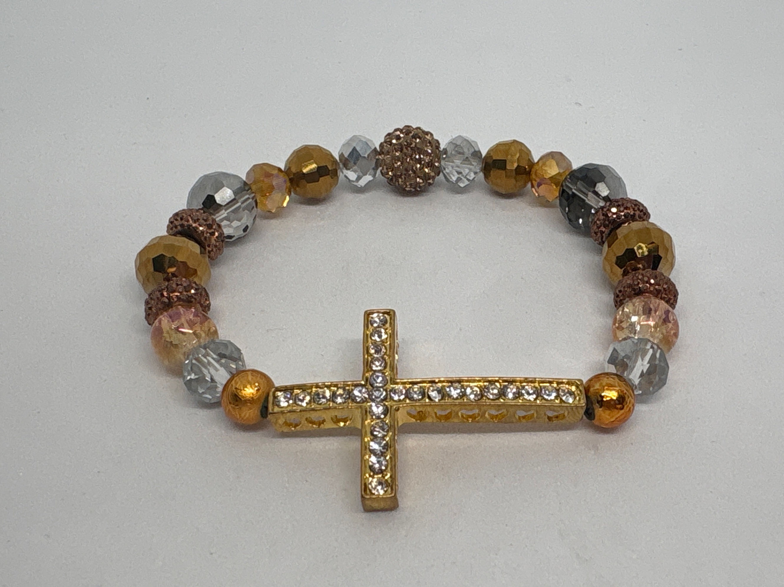 Gold, bronze, clear, colored beading with gold cross Forgiven Bracelet.