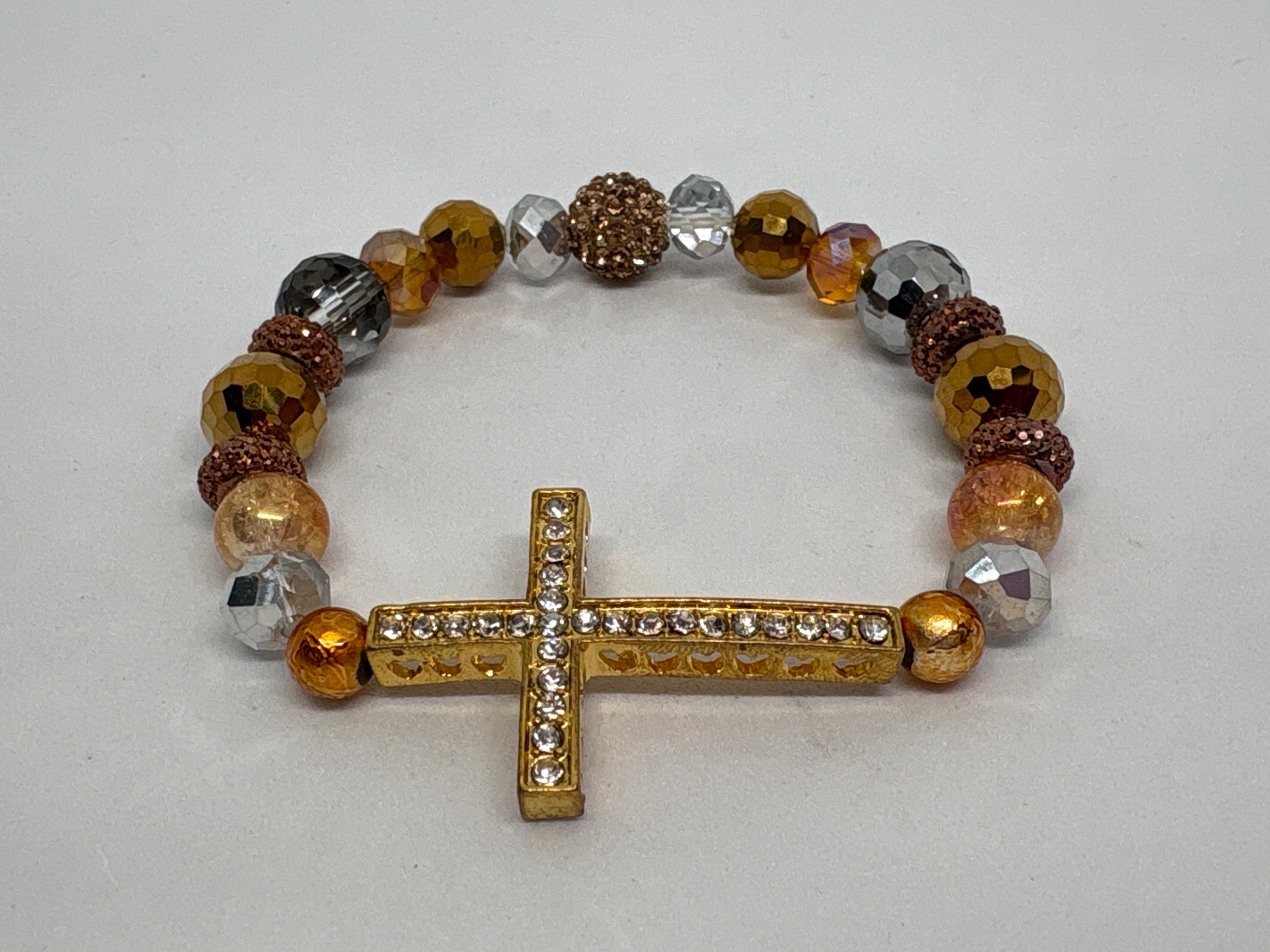 Gold, bronze, clear, colored beading with gold cross Forgiven Bracelet. 