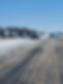 A snow covered roadway with traffic congestion and a stranded commercial vehicle in the median.