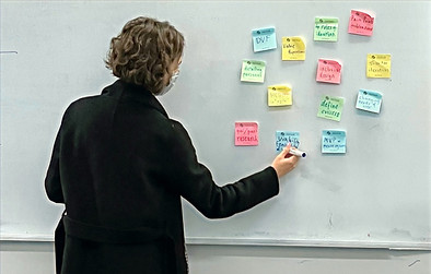 Finley teaching a design workshop with sticky notes on a whiteboard